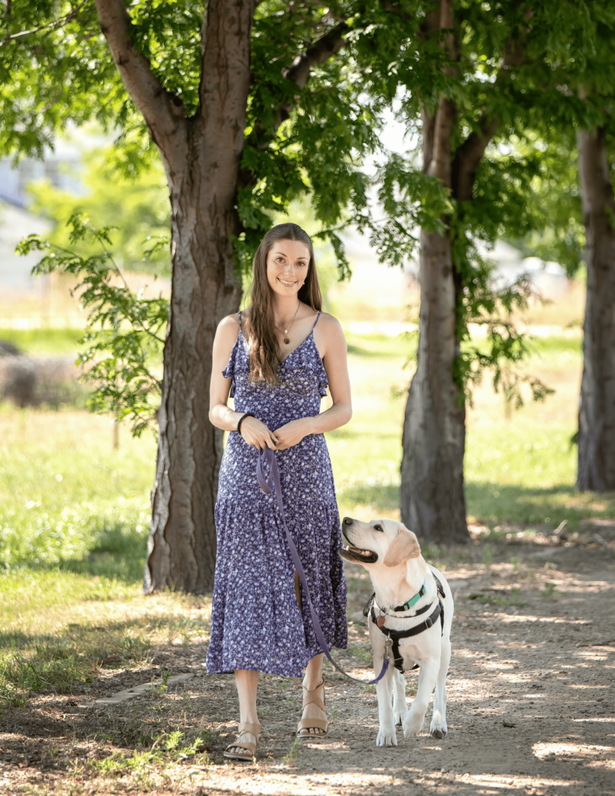 Client Courtney smiles next to her hearing dog a yellow lab named Caro.