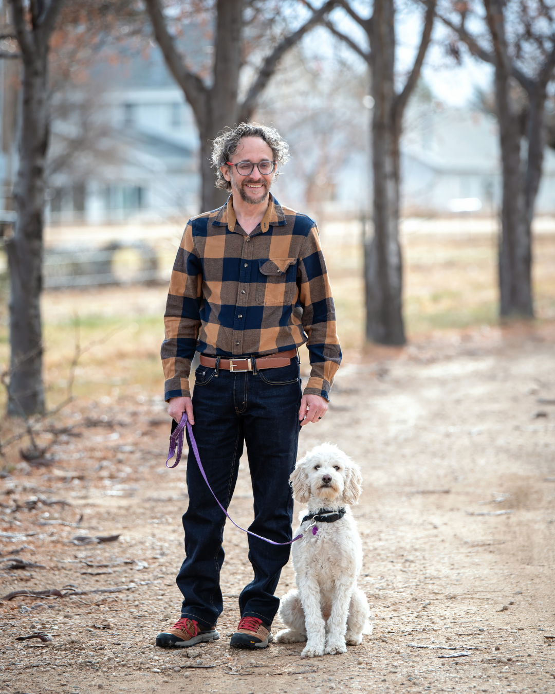 Client Matt smiles next to her hearing dog a cream Cobber Dog named Eddie.