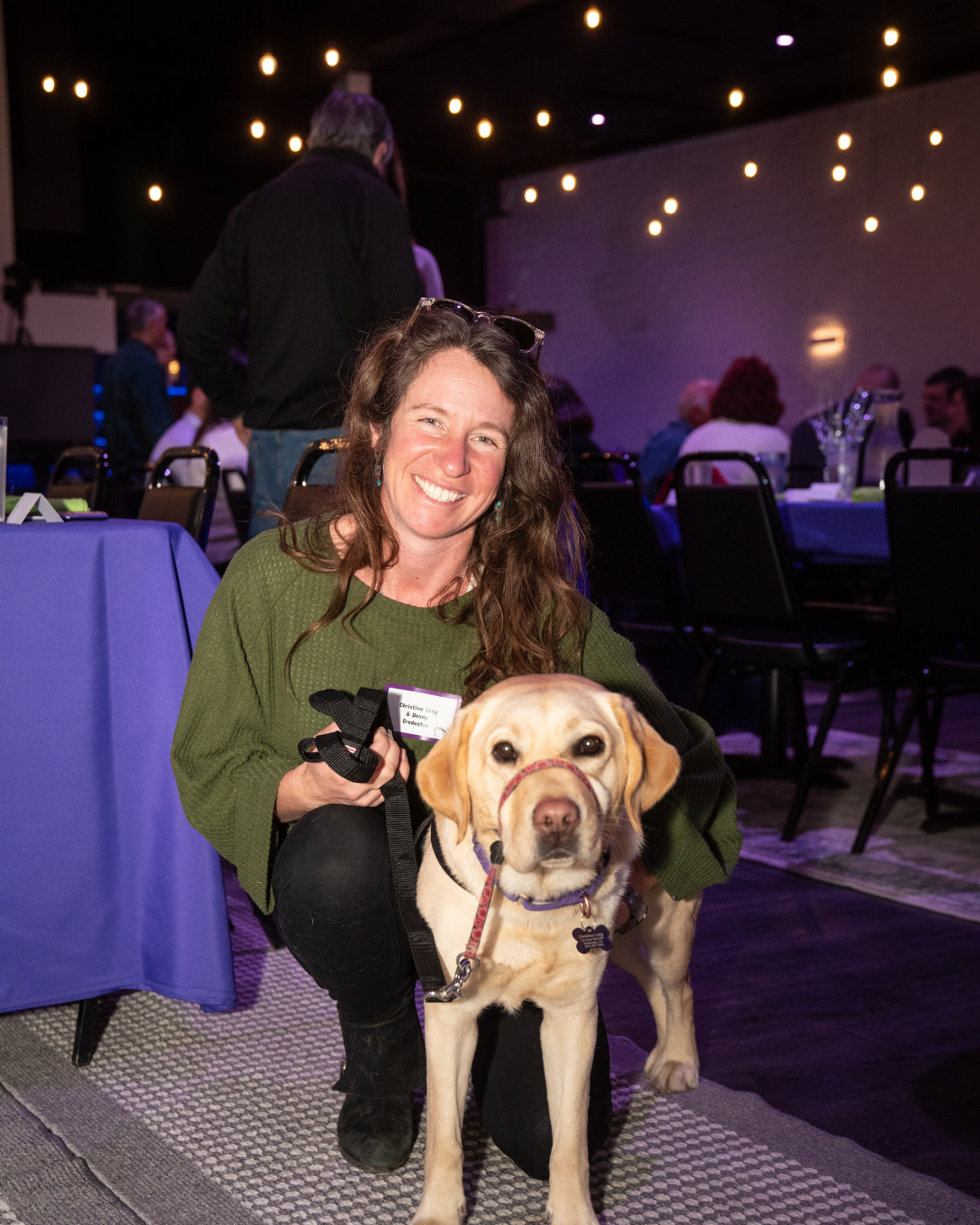 Christina smiling next to her hearing dog Dancer.