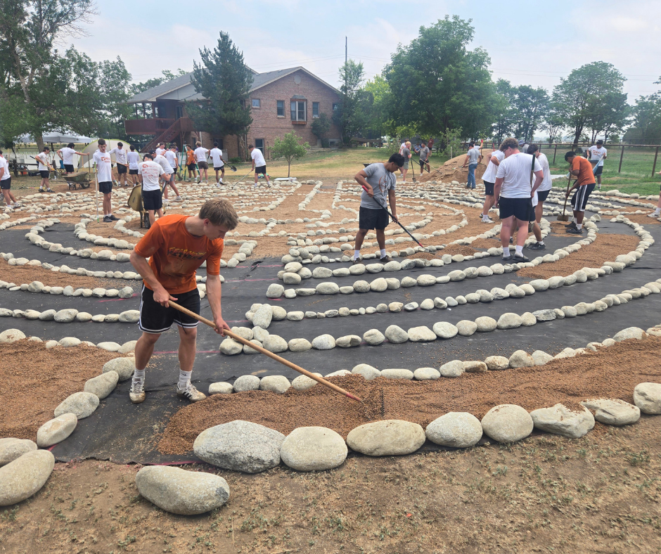 High Schoolers use rakes to even out the gravel inside the labyrinth. 