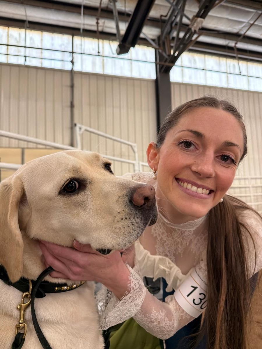 Courtney and Caro who is a yellow lab smiling at the camera. 
