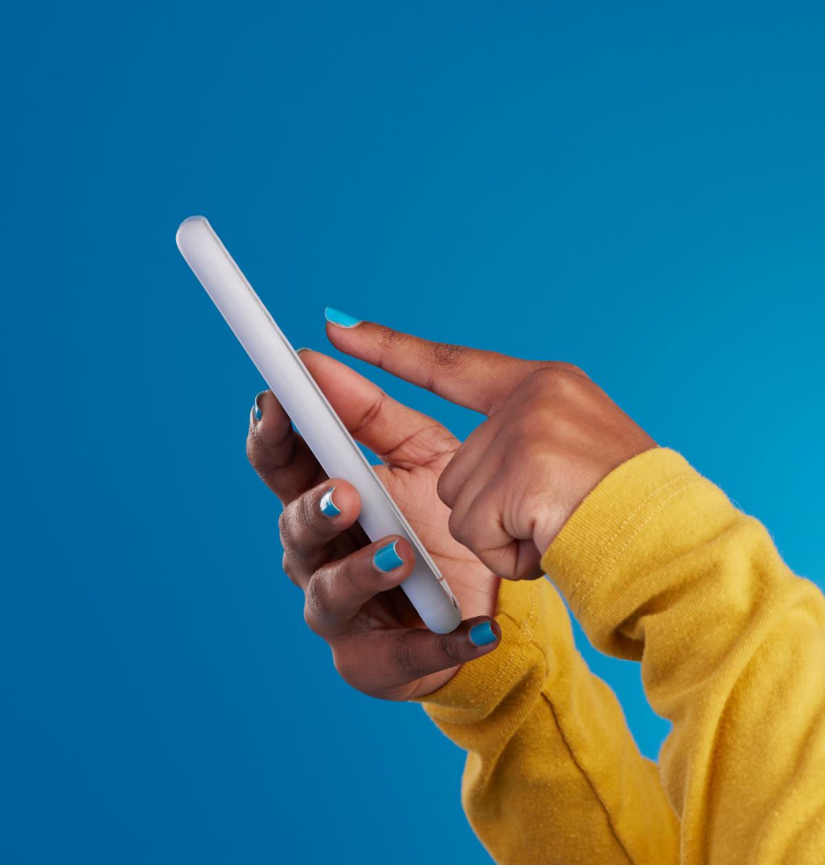Phone typing and hands of woman point to screen in studio for social media text message and website. Communication technology and girl on internet networking and chat online on blue background