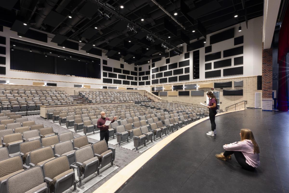three students stand in the new auditorium built in Francis Howell North High School