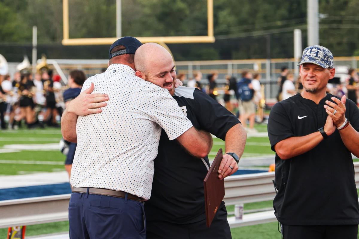 Francis Howell Central GAC Hall of Fame Inductee Jackson Berck hugs a colleague holding his award plaque
