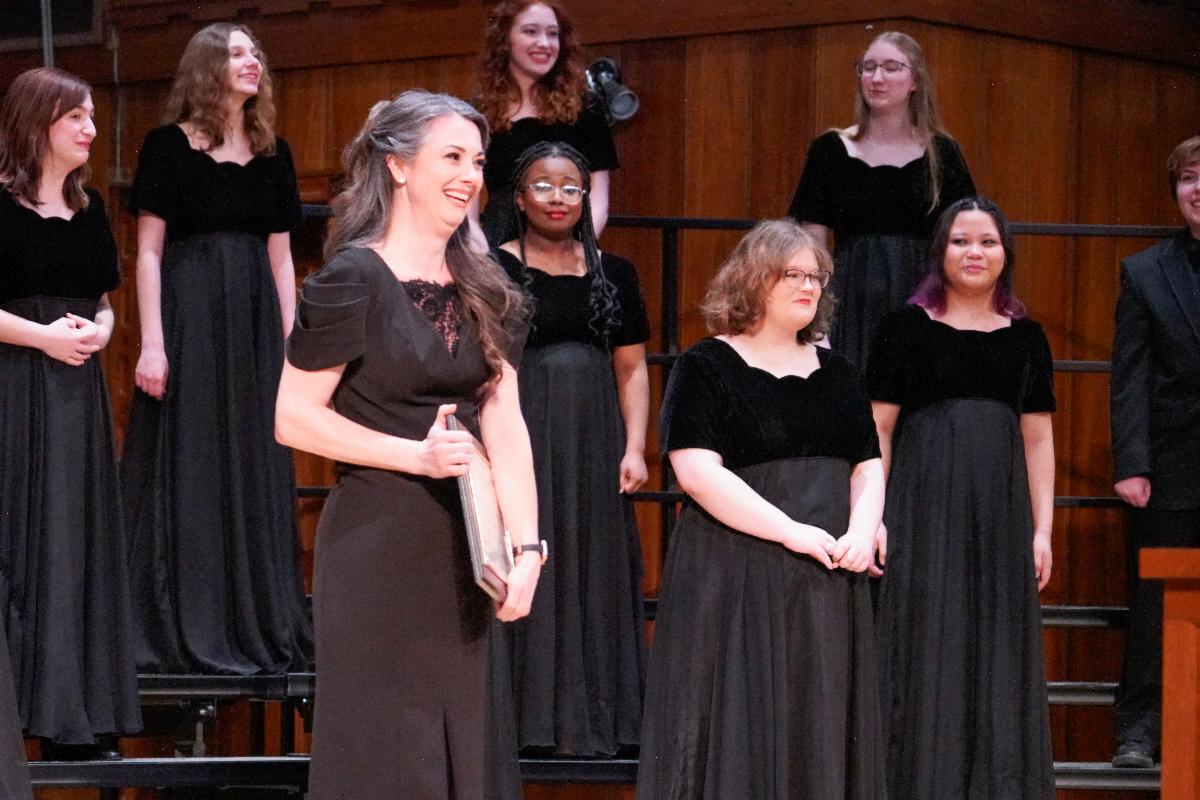 Jennifer Oncken smiles while holding a plaque following a performance of the Bella Voce choir
