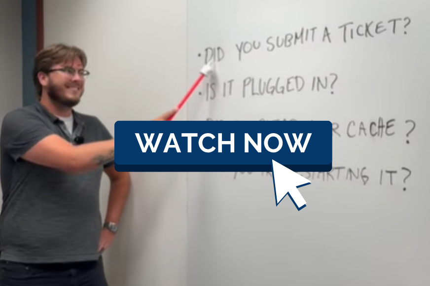An IT professional uses a pointer to read along with words on a whiteboard. A button with a mouse pointer reading "watch now" overlays the image