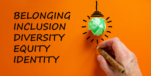 Belonging symbol. Businessman writing  identity_ equity_ diversity_ inclusion_ belonging _ orange background. Light bulb icon. Business_ belonging_ diversity and better inclusion concept. Copy space.