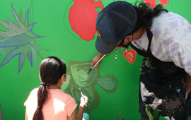 Isidro paining with community member
