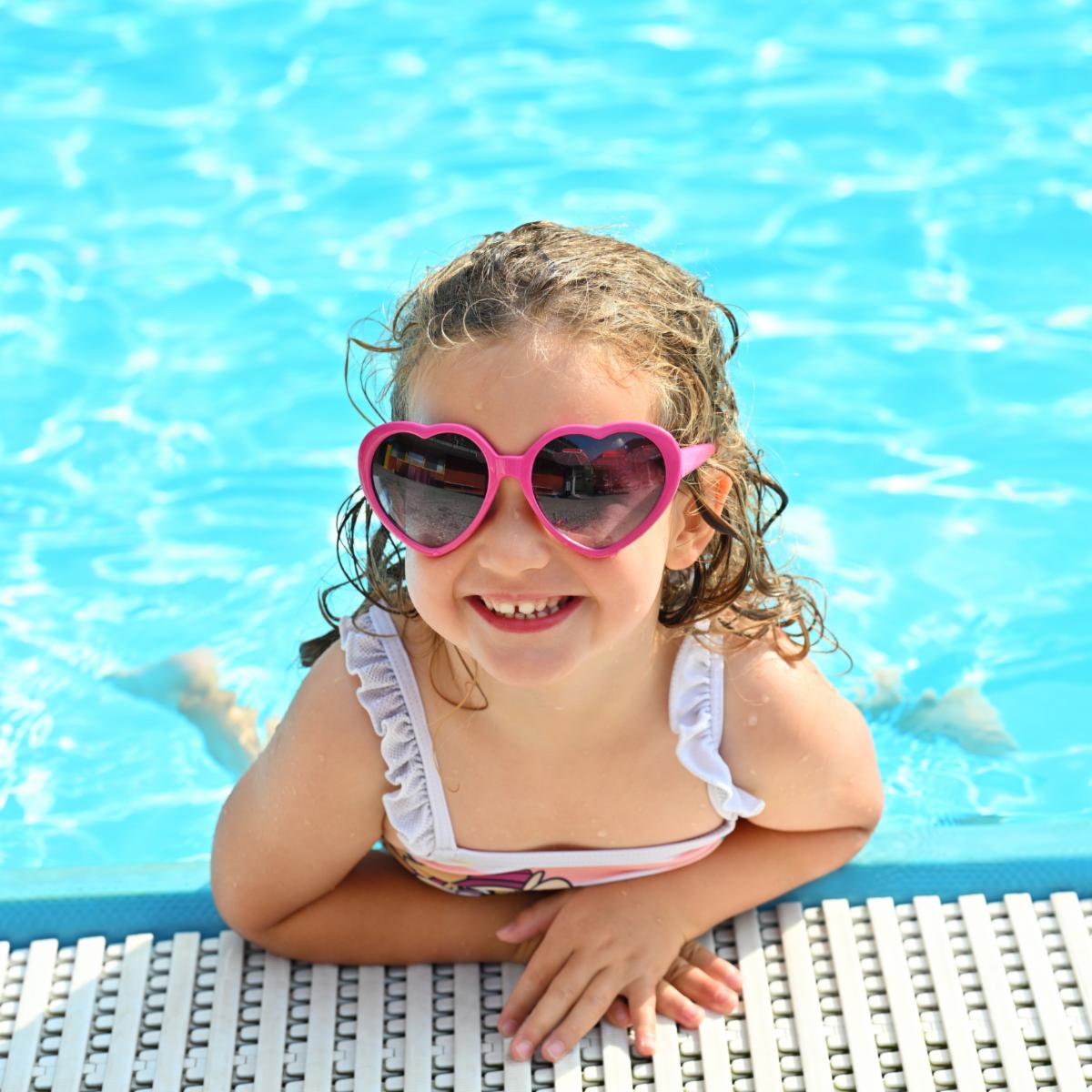 Portrait of happy little girl in the swimming pool