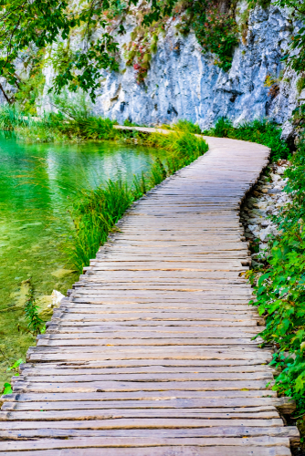 Wooden pathway and clear water in National Park Plitvice Lakes in autumn_ Croatia