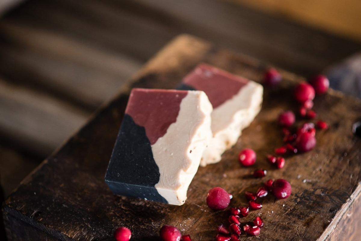 Image of two bars of homemade soap with dried cranberries next to it