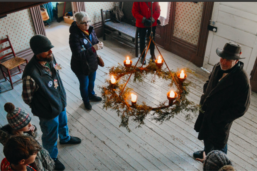 group of people standing in an old historic building decorated for christmas