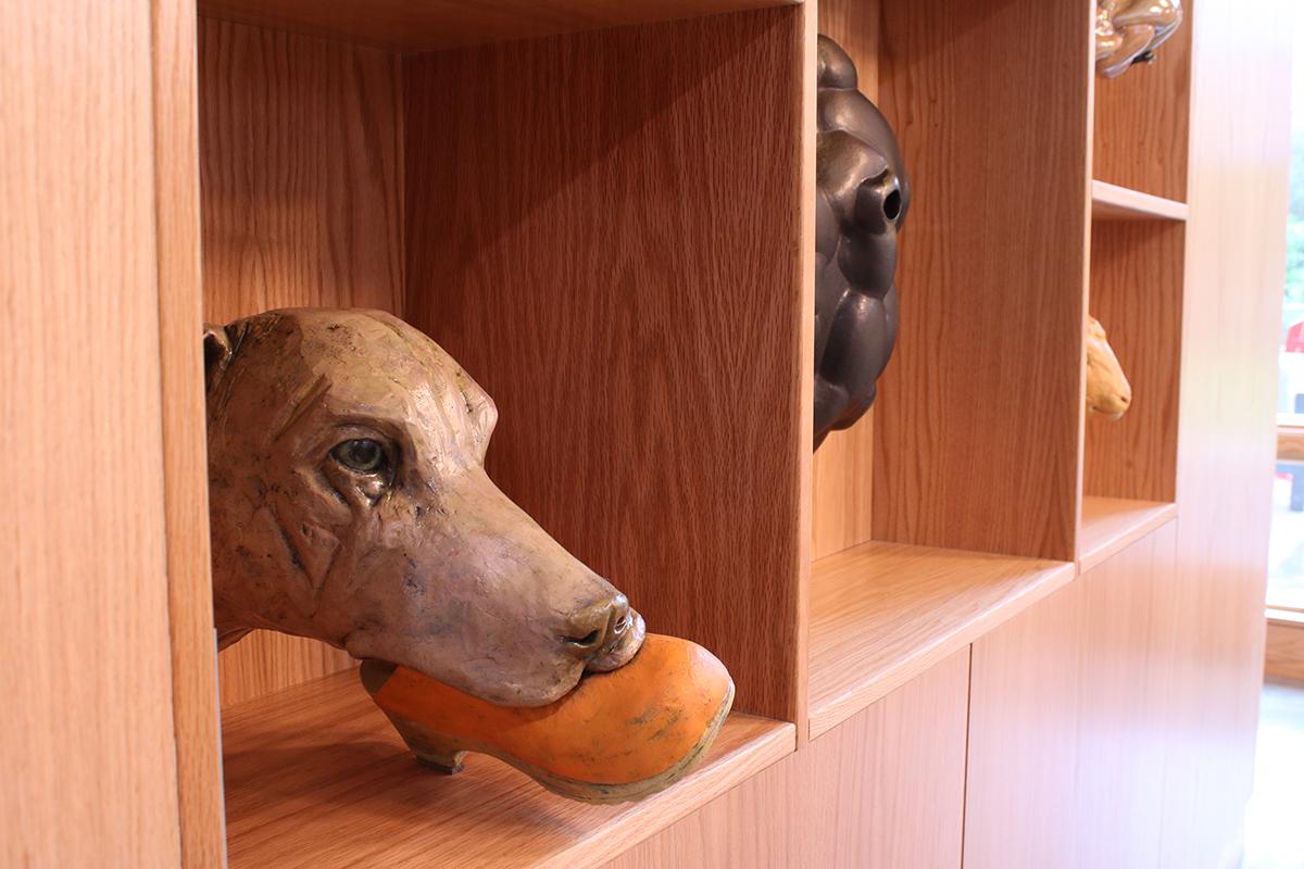 Photo of Good Girl HasBeen, 2021, by Crista Ames. Sculpture of the head of a dog, holding a shoe in its mouth.