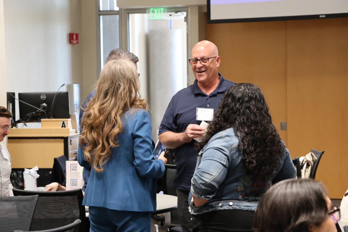 Attendees of the June HIPMC partner meeting socializing with one another during a break