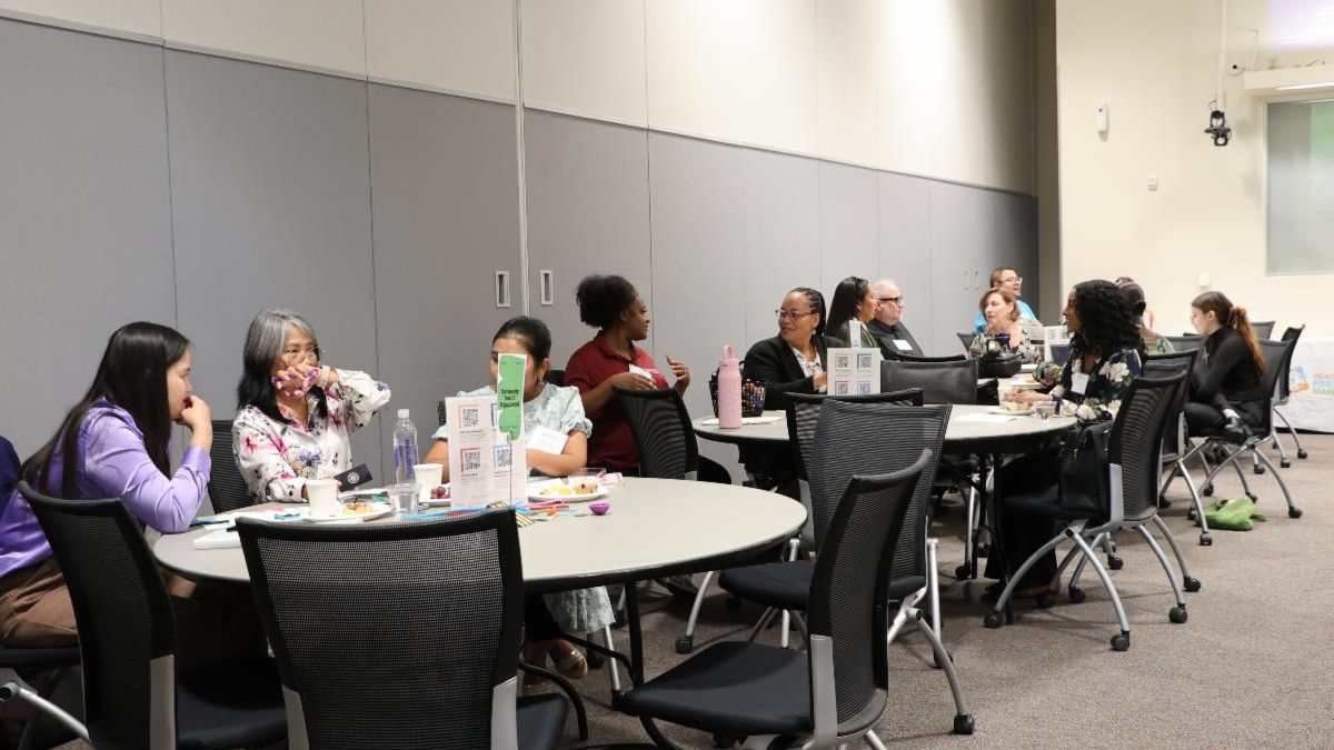 Attendees of the June HIPMC partner meeting socializing with one another during a break