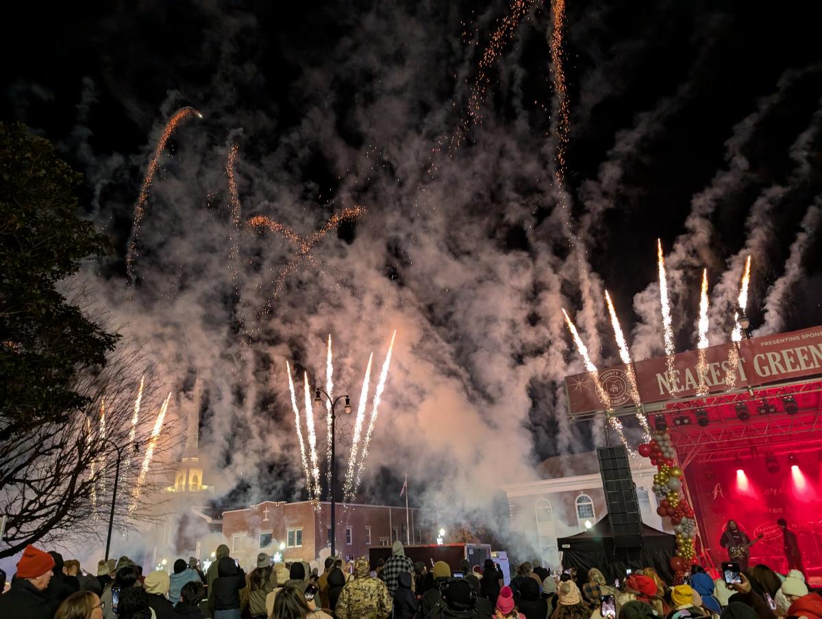 Fireworks are released, with the festival stage and First United Methodist Church in the background.