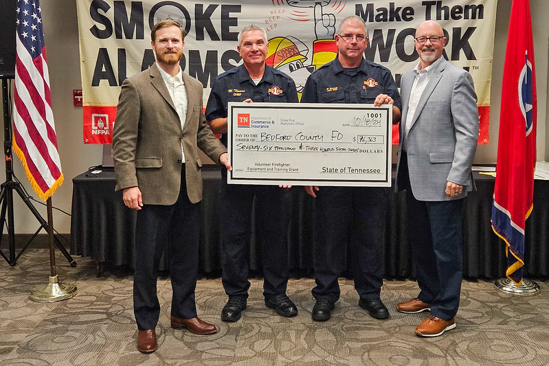 Bedford County Fire Department officials, flanked by state officials, pose with a replica grant check.