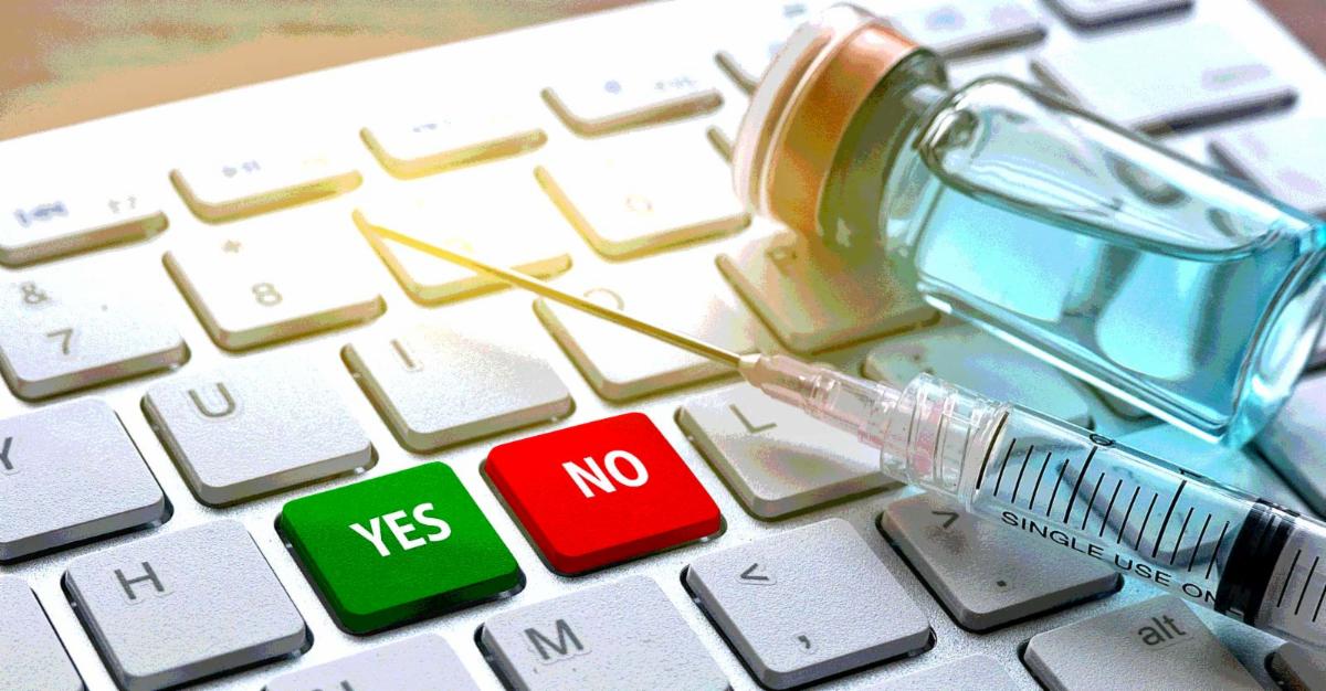 vaccine bottle on keyboard with words "yes" and "no"