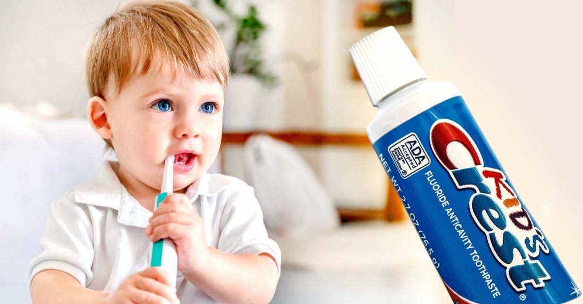 toddler brushing teeth and bottle of crest kids toothpaste