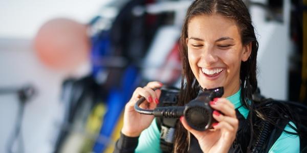 Photo of a woman diver getting geared up for her dive on a dive boat.
