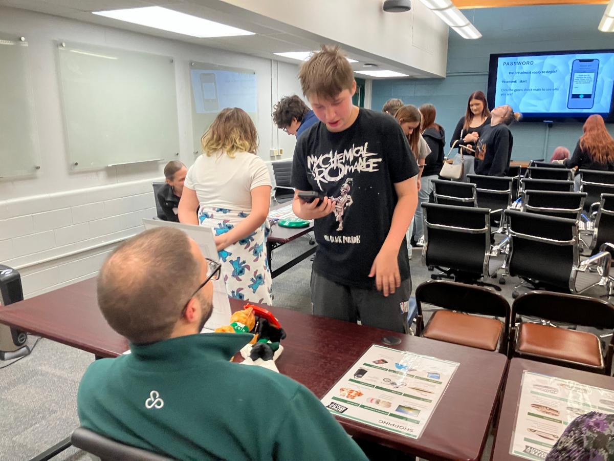 Teen chatting with staff at a community information table.