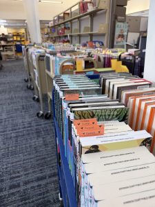 Rows of library book bins filled with returned or reserved books.