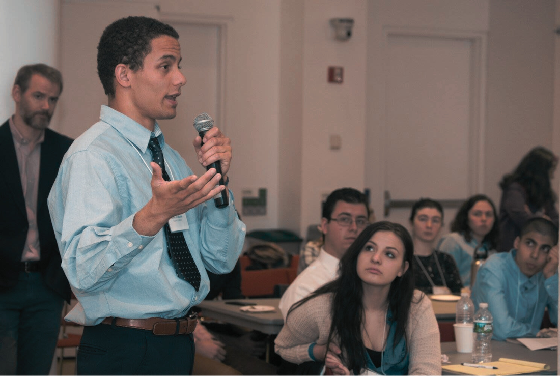 Image of a classroom where a speaker is explaining something on a mic. 