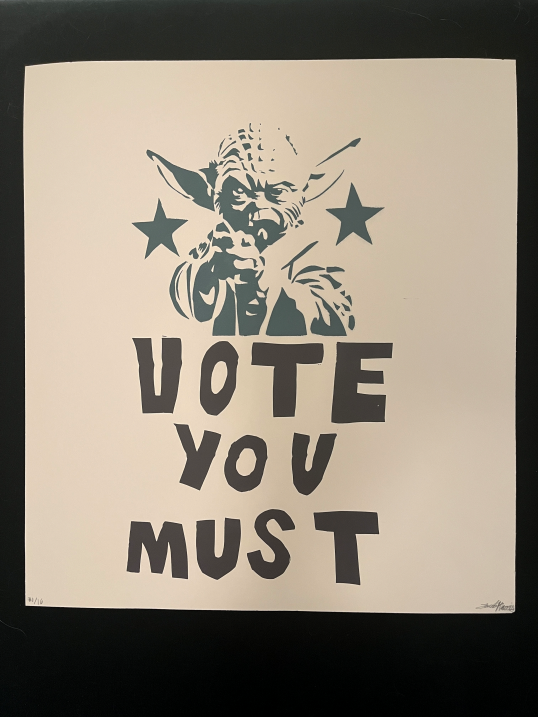 A screenprinted poster with a miniature Yoda who points at the viewer and says "Vote You Must" 