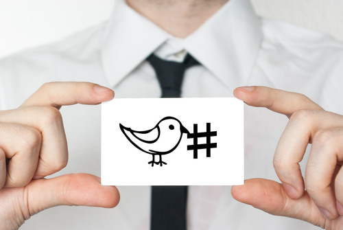 Social media hashtag tweet. Businessman in white shirt with a black tie showing or holding business card