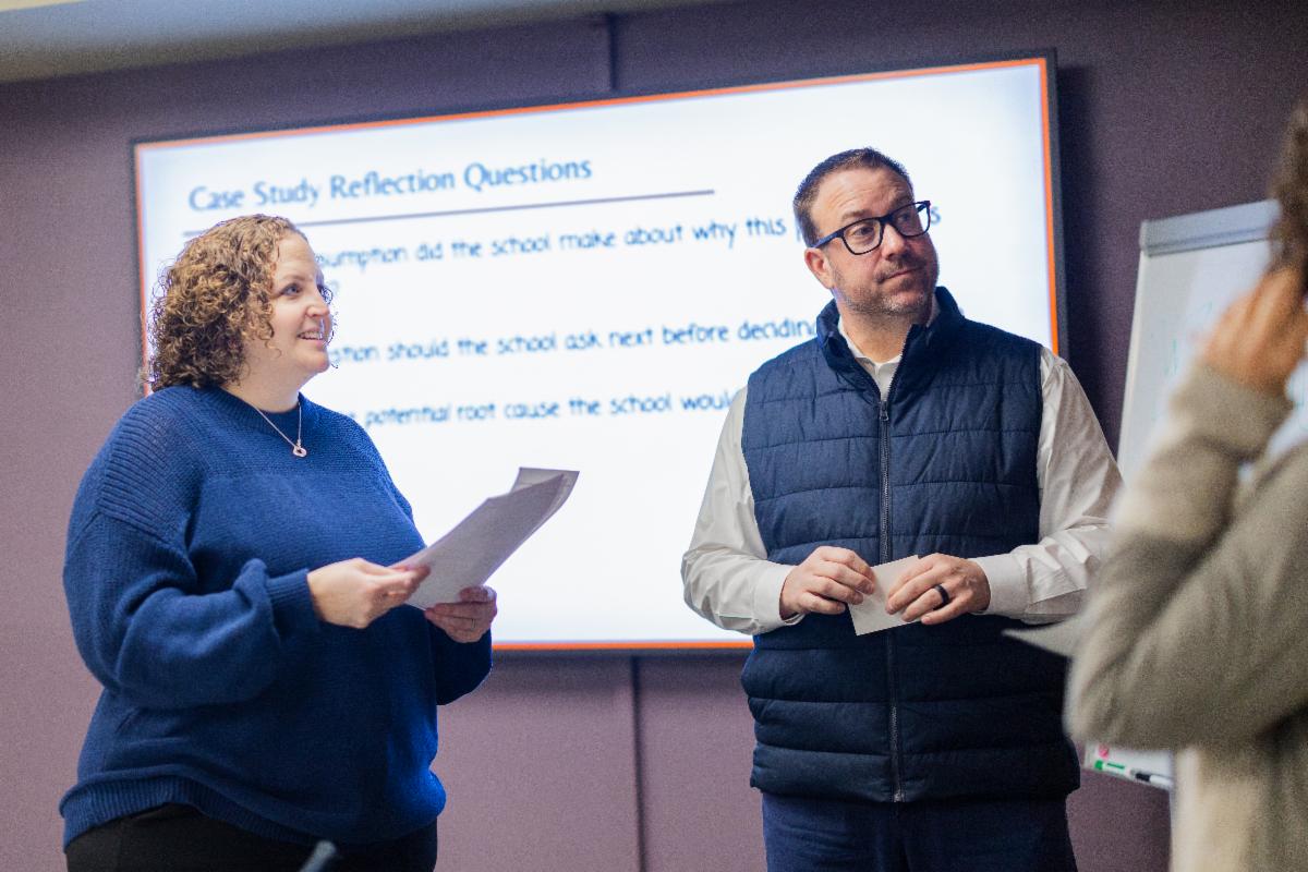 Two adults listening to person talking offscreen