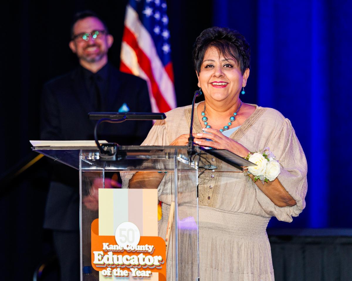 The 2026 Kane County Educator of the Year giving a speech at a podium