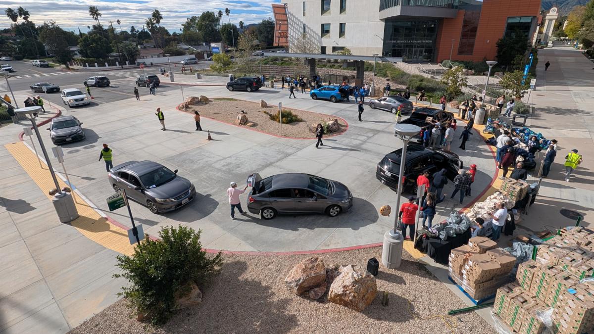 Cars lined up in a round-about with volunteers distributing turkeys at the event