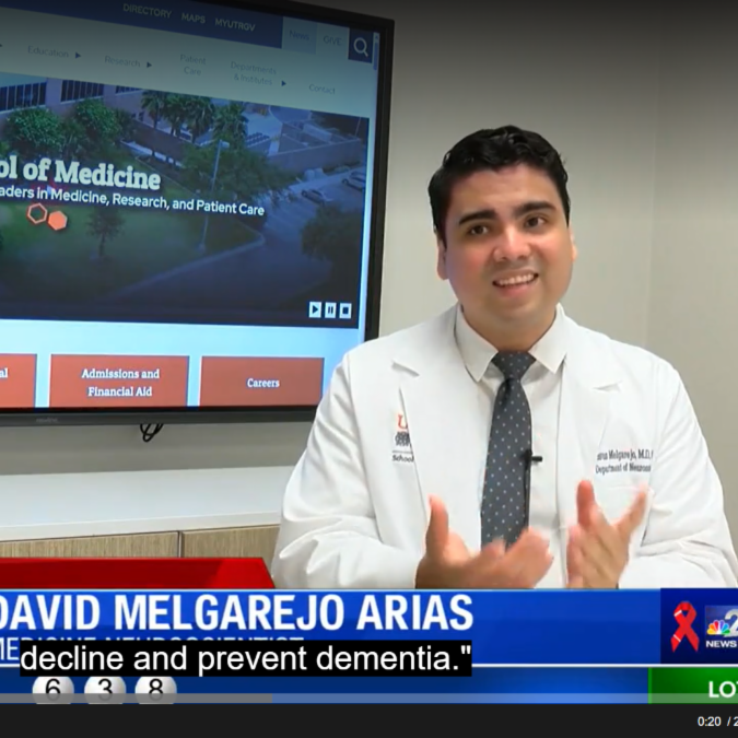 A doctor in a white coat sits in front of a screen displaying the UTRGV School of Medicine website. A news ticker below shows his name and school affiliation.