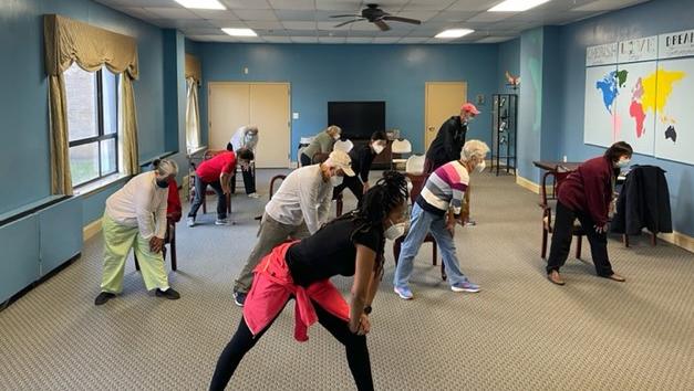 young woman leading residents in an exercise class