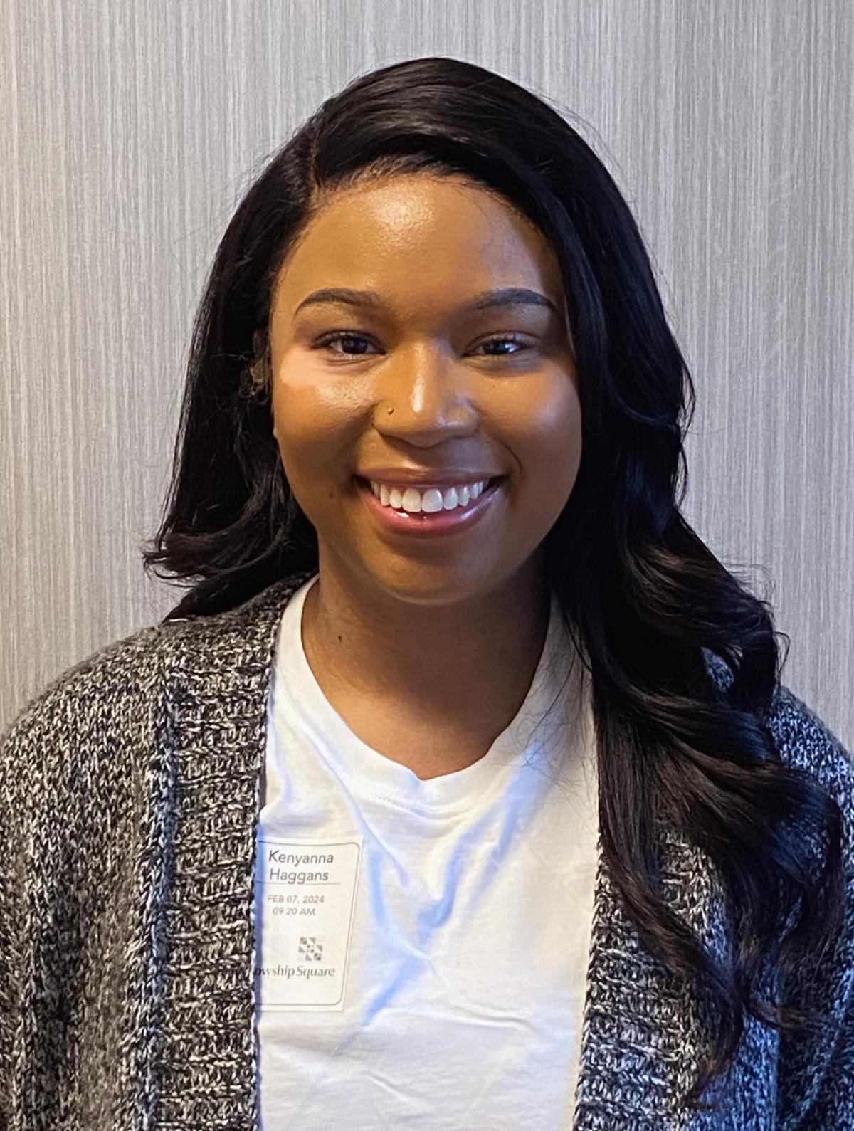 Headshot of Kenyana young woman with grey sweater and white shirt