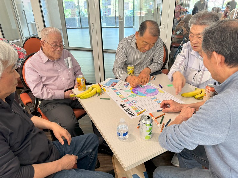 five men coloring a poster for earth day