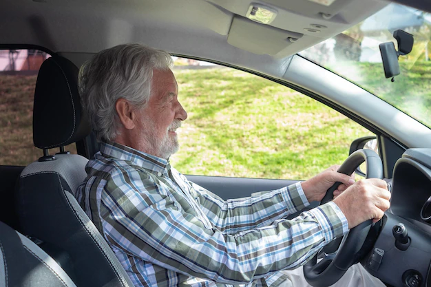 older man seated behind the wheel of a car