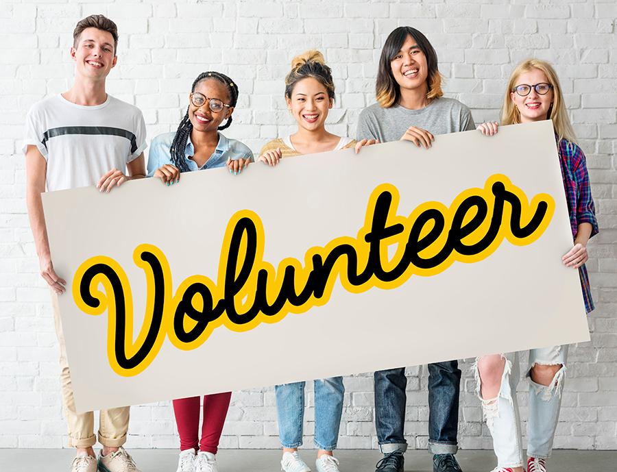 group of young people holding a sign that says volunteer