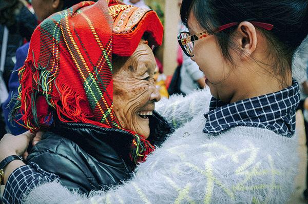 young asian woman embraces a smiling older asian woman