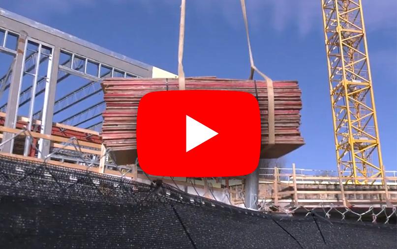 Construction crane with a blue sky behind it and a YouTube video logo on top of the photo