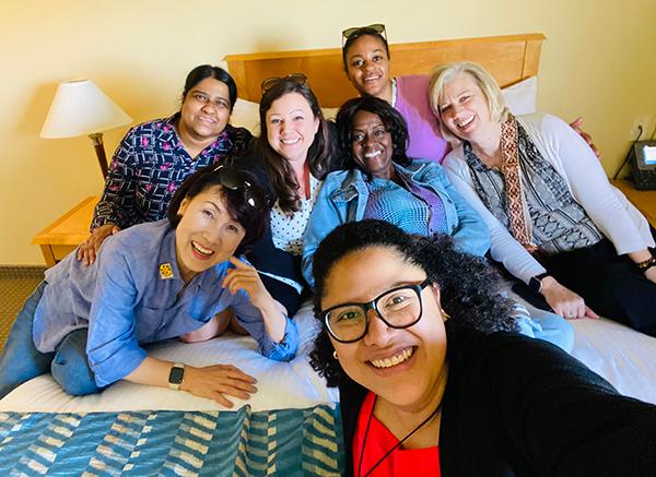 group of people posing together in a hotel room