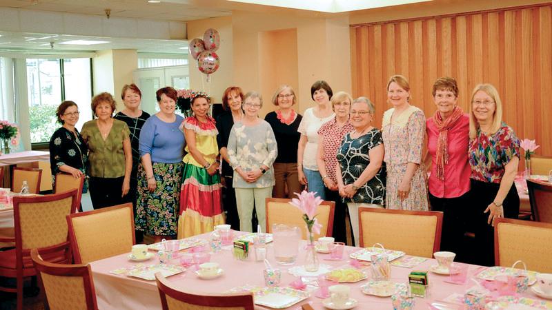 A group of women standing together behind a table Gail is on the far right