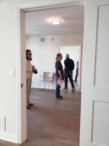 view through a doorway of people touring a room