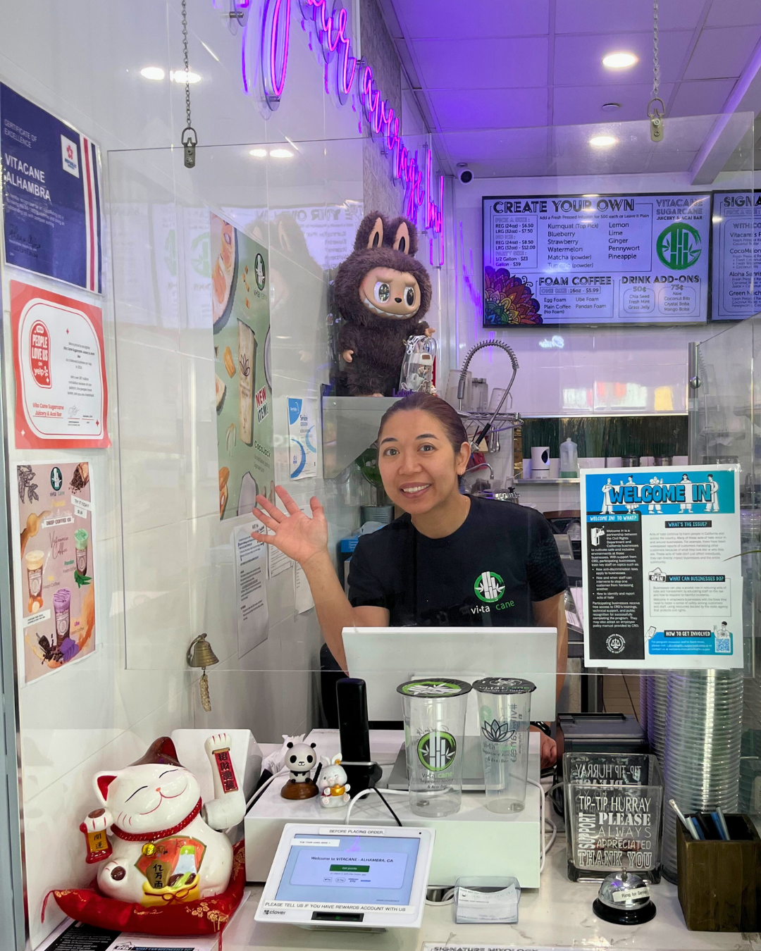 Allison the owner of Vita Cane juicery and acai bar in Alhambra waves from behind the cash register.