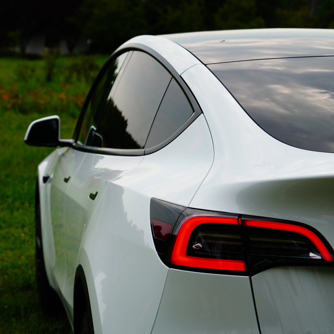 A white Tesla parked on the side of the road.