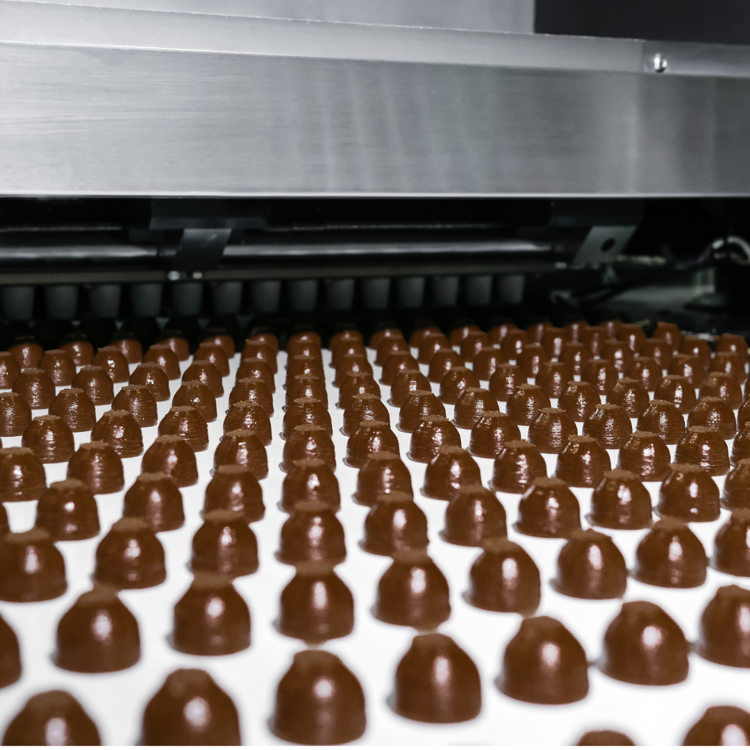 chocolate candies on a conveyor belt.