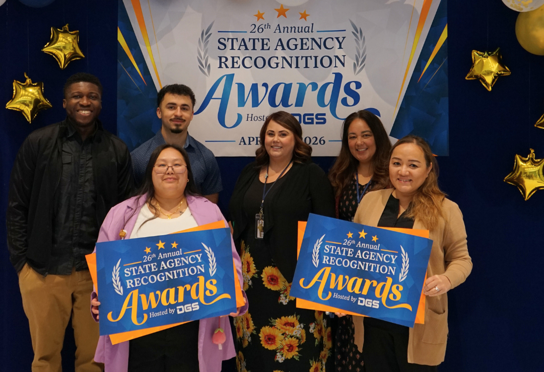 California Civil Rights Department staff stand together at the 26th Annual State Agency Recognition Awards with blue and gold balloons and star decorations.