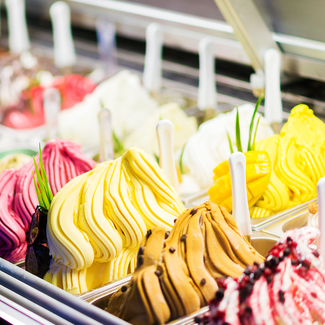 Various flavors of ice cream in a display case inside an ice cream shop.