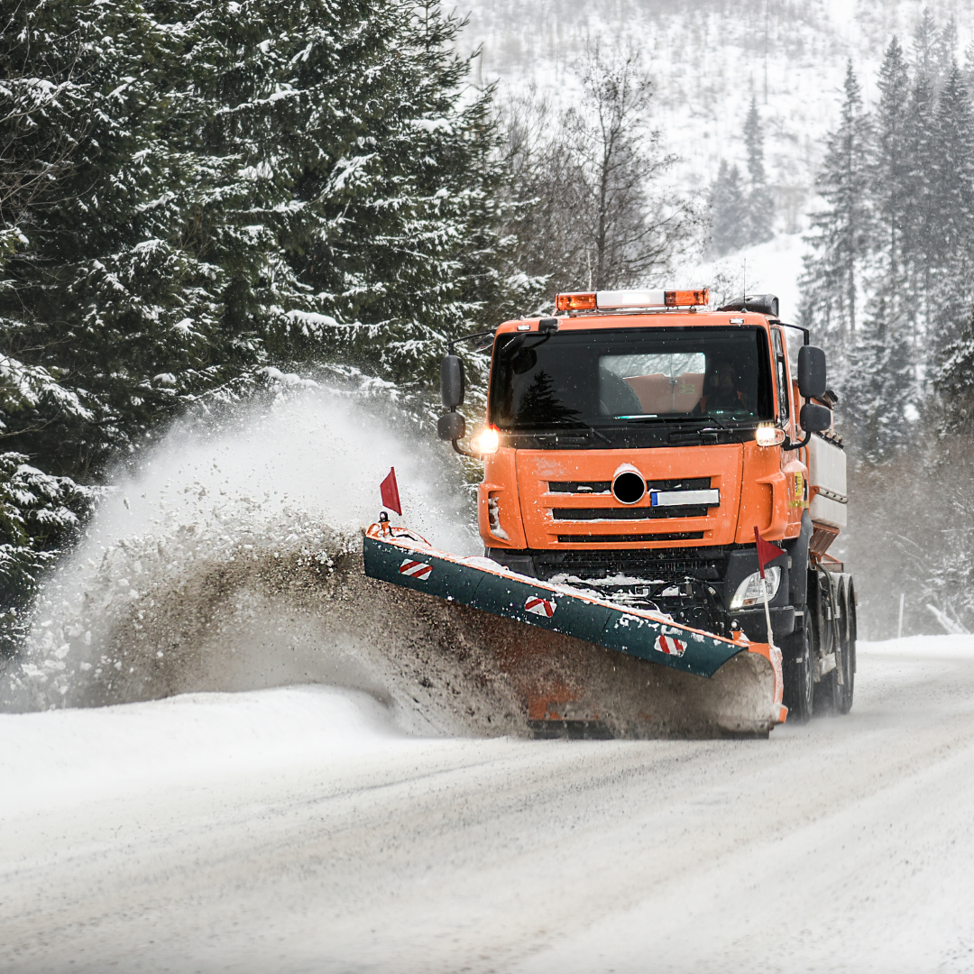 A snow truck removes snow from the road.