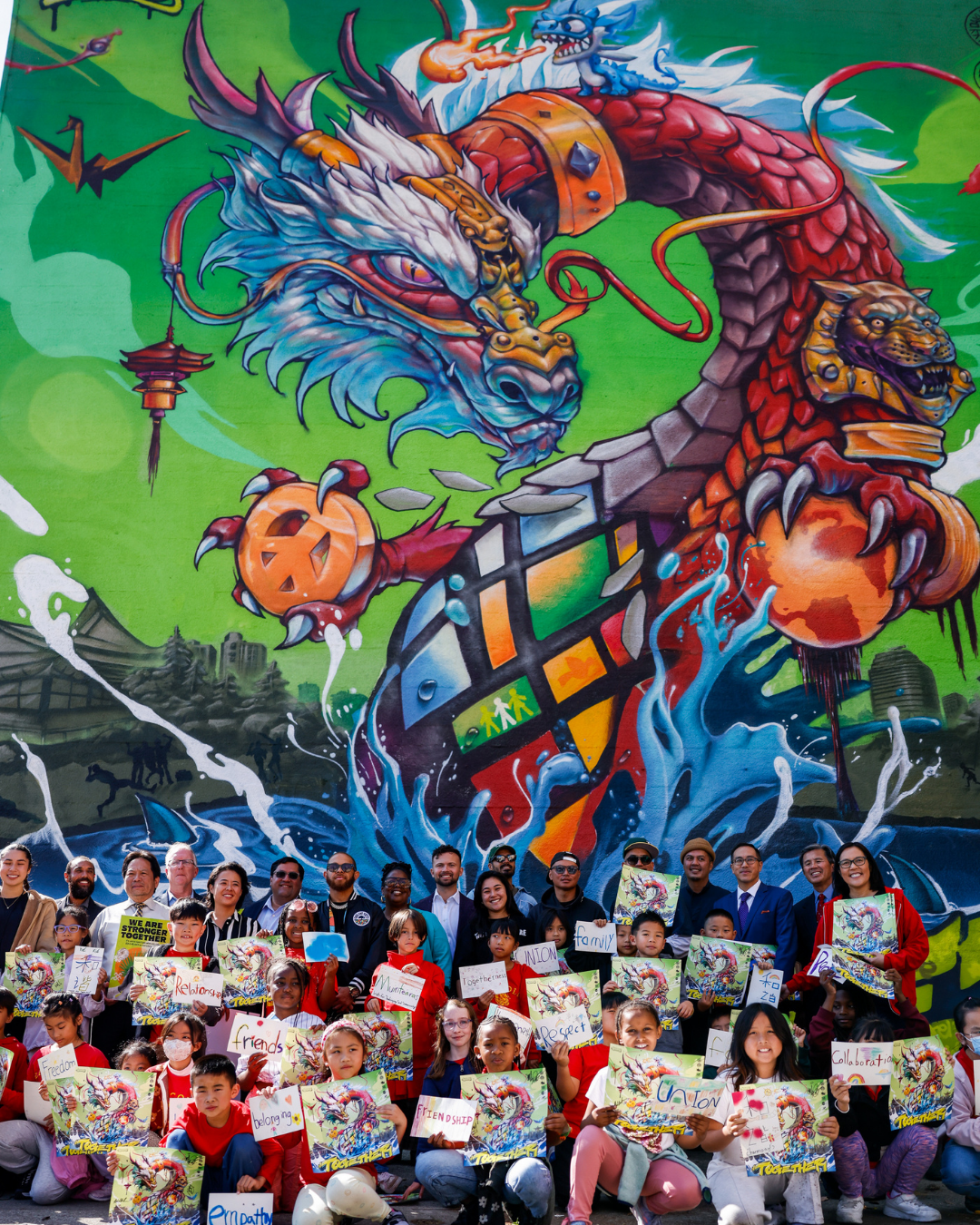 California Civil Rights Department staff stand with government and community partners in front of the department's new mural in Oakland.